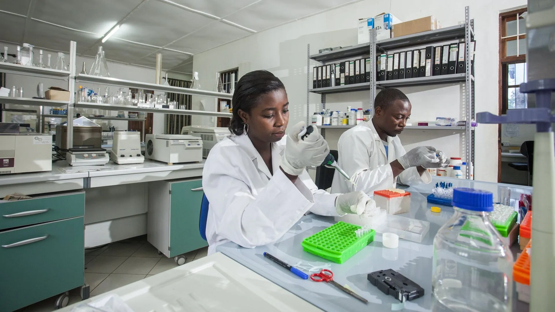 A man and a woman are working in a lab.